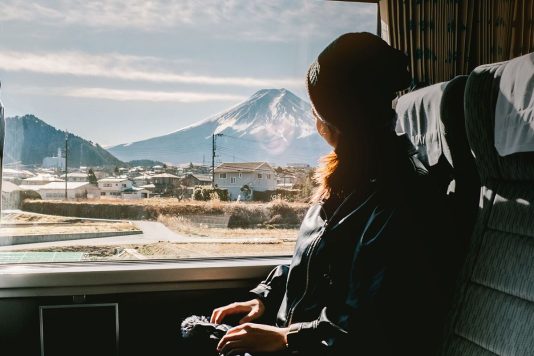 Woman on train looking out of window at mountain