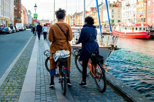 Two travelers on bikes next to a canal