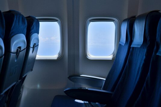 Two empty airline seats positioned toward the window